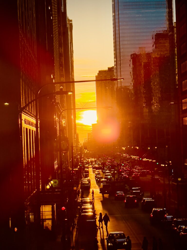view of the sun setting in line with the streets of chicago during a phenomenon known as chicagohenge
