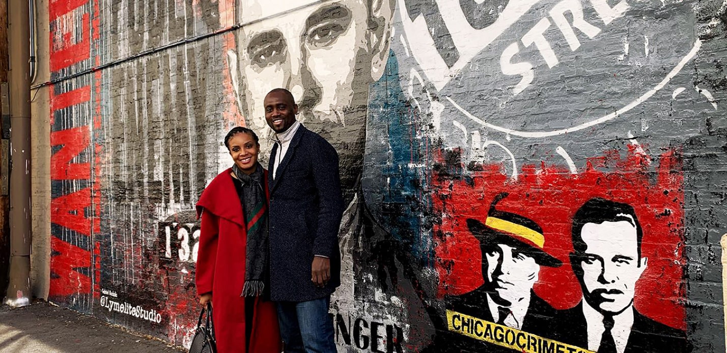 couple standing in front of the john dillinger mural on a chicago crime tour