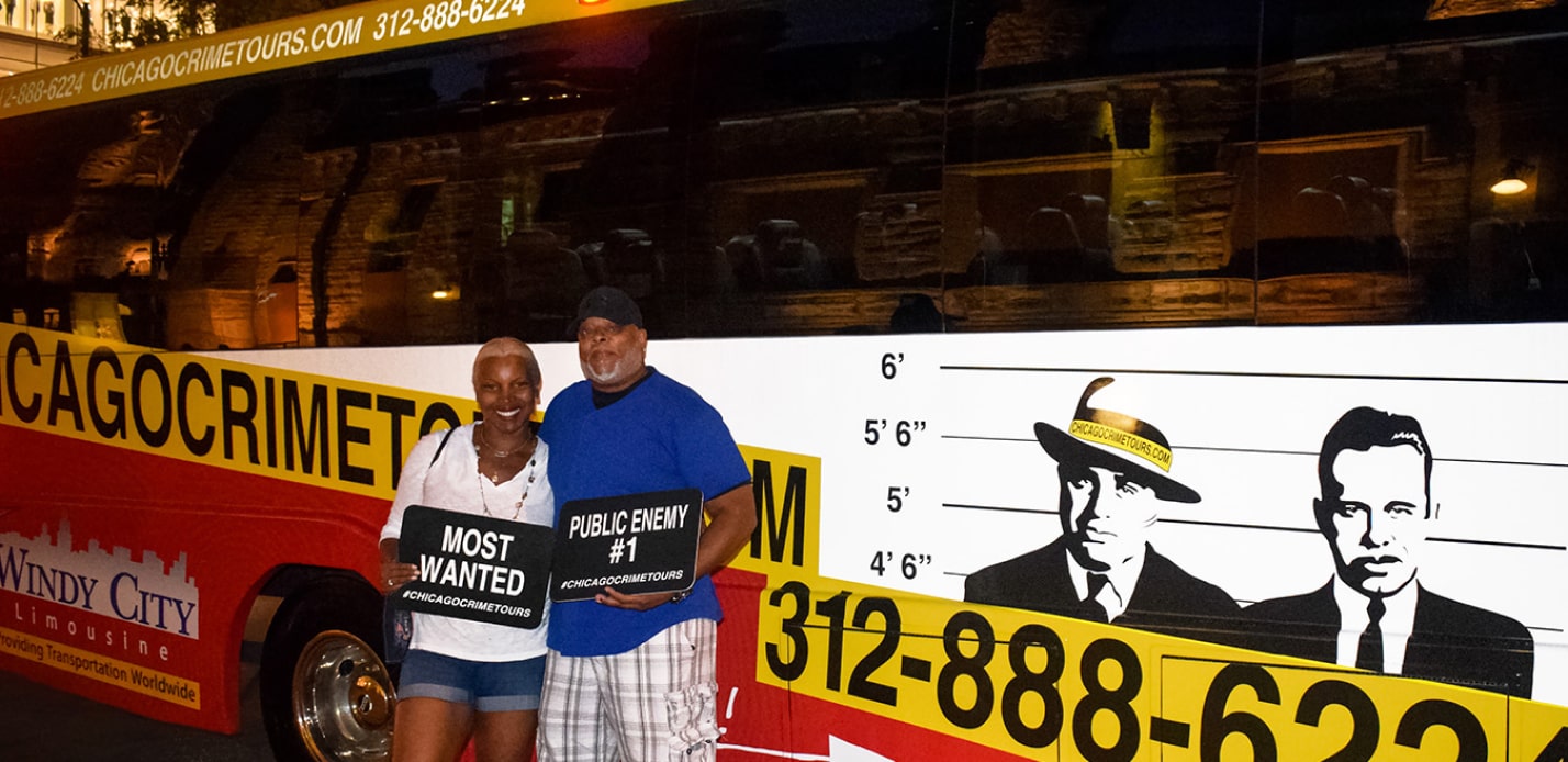 couple on front of the chicago crime tour bus on a chicago night crimes tour